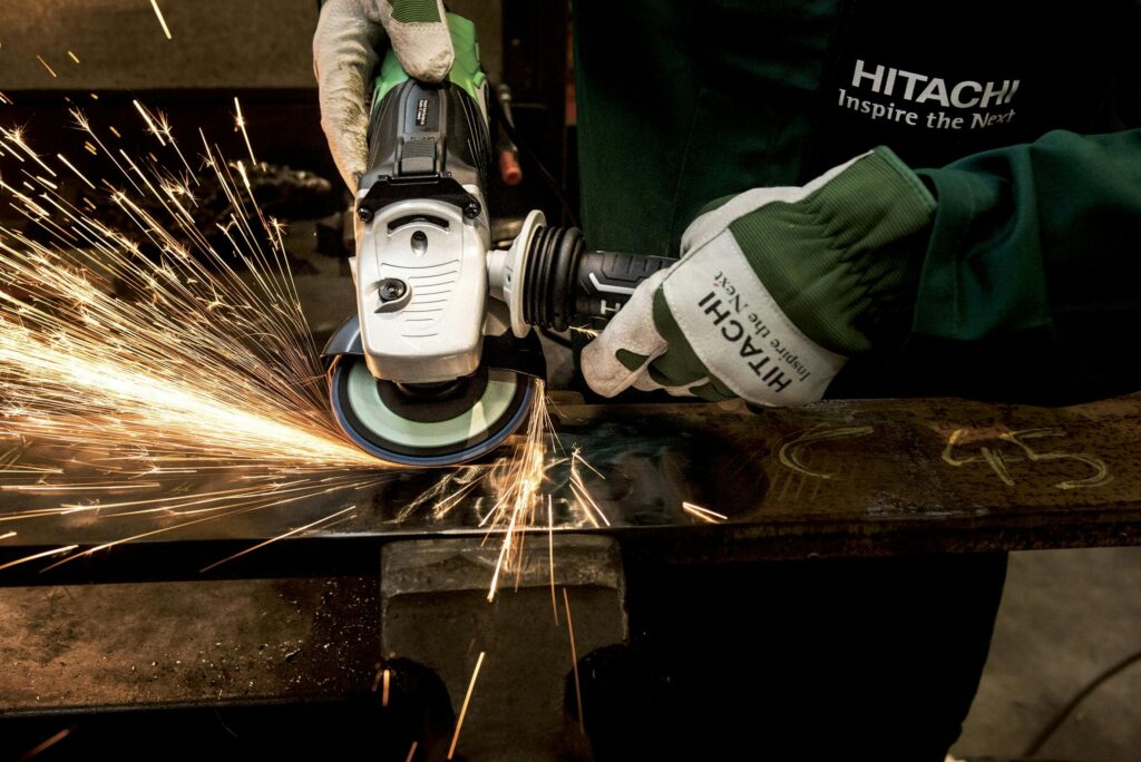 Close-up of a skilled worker using a grinder with sparks flying in a metal workshop.