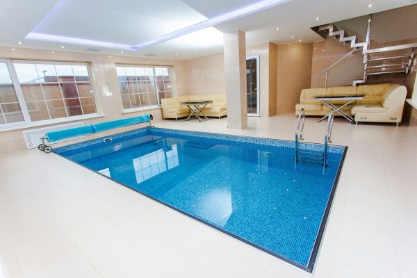 Luxurious indoor pool area featuring modern design and elegant furnishings.